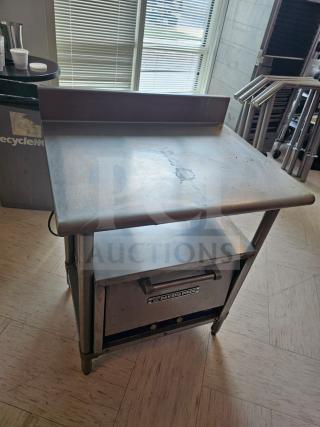 Stainless steel stand with shelf; used condition. "Bakers Pride" label on front. Interior content not included.