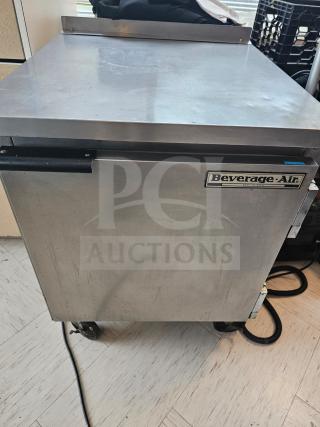 Beverage-Air WTF27A commercial undercounter refrigerator, stainless steel, visible wear, black handle, on wheels.