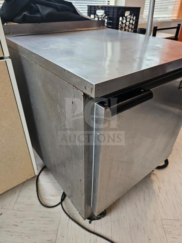 Beverage-Air WTF27A commercial undercounter refrigerator, stainless steel, visible wear, caster wheels, handle on door.