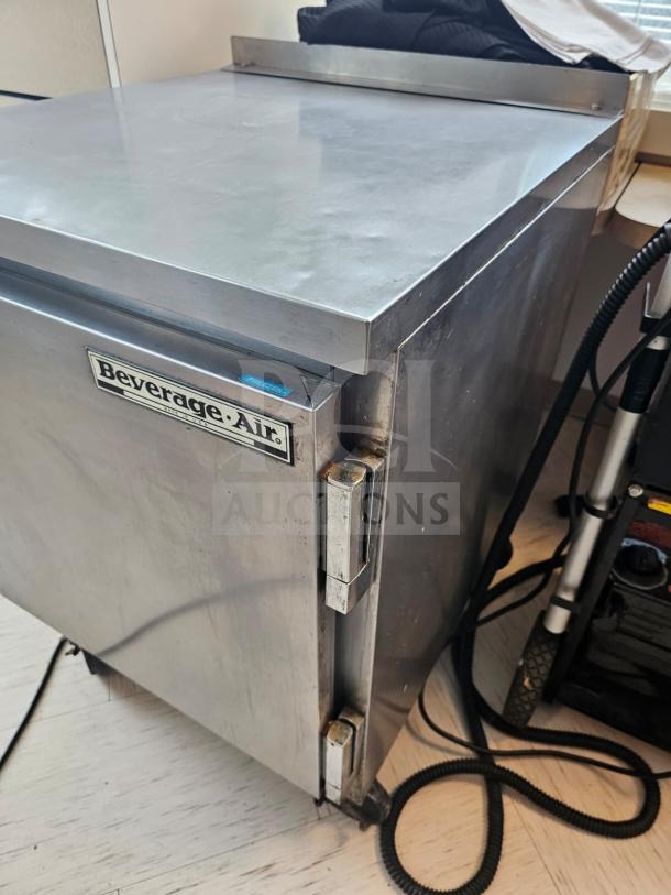 Beverage-Air WTF27A commercial undercounter refrigerator in stainless steel, features visible hinges and brand label, moderate wear.