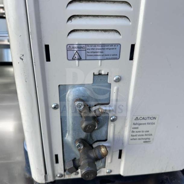 Fujitsu AUU24RLB 24,000 BTU outdoor condenser unit, fully operational. Warning and caution labels visible.