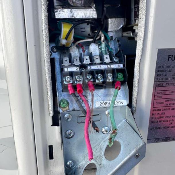 Fujitsu AUU24RLB condenser unit, 208/230V, 24,000 BTU, elite condition, wiring exposed, label with model and voltage info visible.