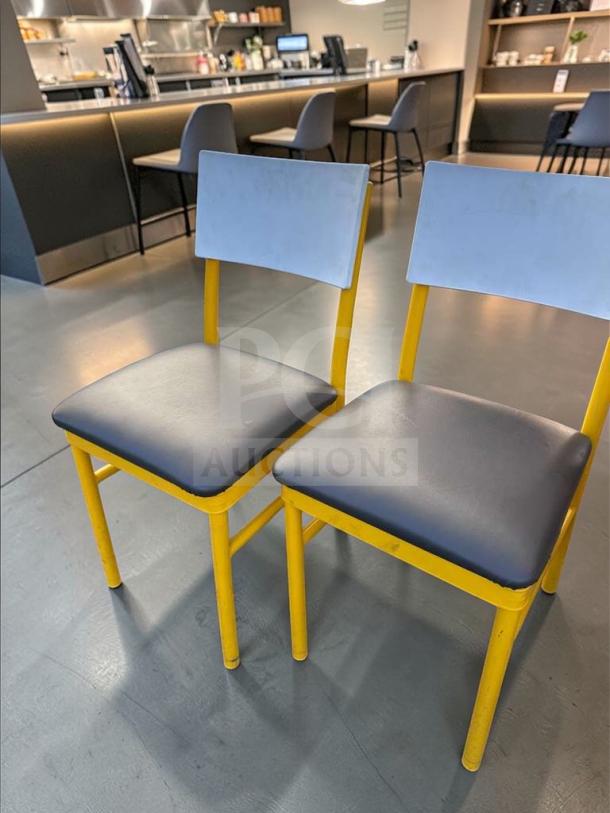 Commercial upholstered dining chairs with heavy-duty yellow metal frames and dark seats, fully inspected.