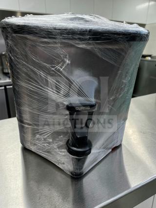 Stainless steel Curtis commercial beverage dispenser in flawless condition, wrapped in plastic, featuring a large capacity and Curtis-branded tap.