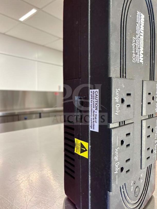 Minuteman EnSpire 400 UPS, 6 outlets, battery backup and surge protection, high-quality condition, visible caution labels.