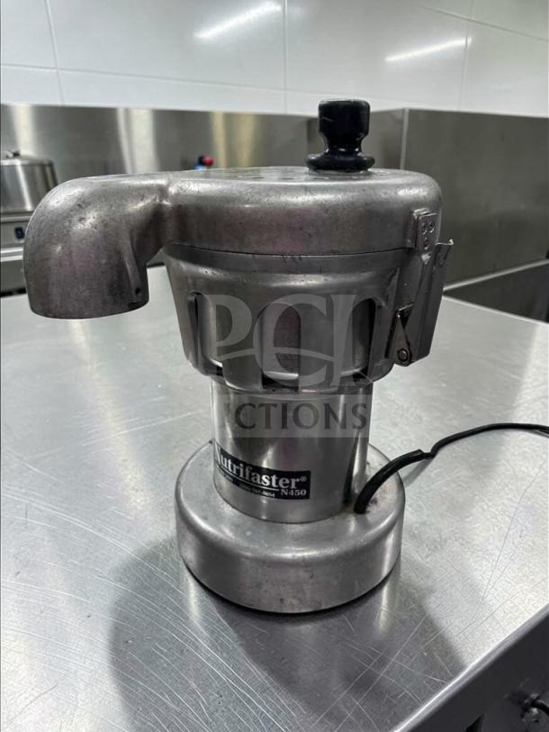 Nutrifaster N450 commercial juicer in stainless steel, elite condition. Model label visible. High-performance, tested operational.