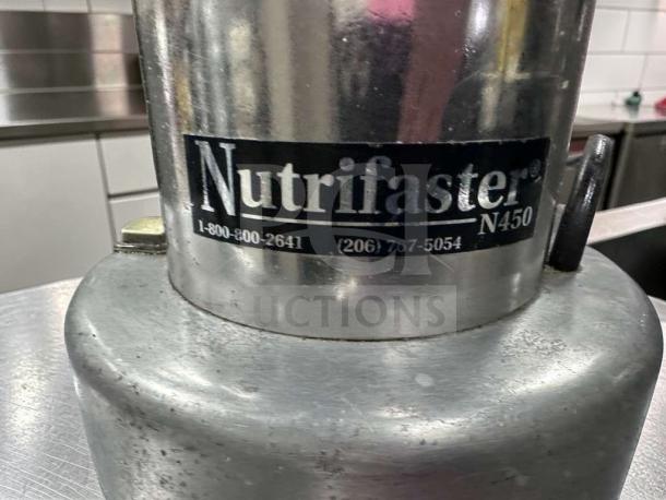 Nutrifaster N450 commercial juicer in stainless steel, elite condition, model and contact info visible on label.
