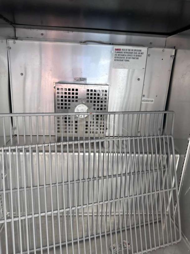 True TUC-27F-LP-HC undercounter freezer interior with shelving, thermostat, stainless steel construction, in superior condition.