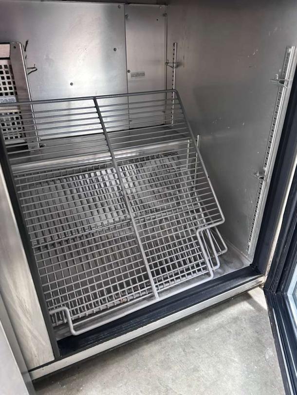 True TUC-48G-HC refrigerator interior with glass doors, stainless steel finish, shelves, excellent condition, fully tested.