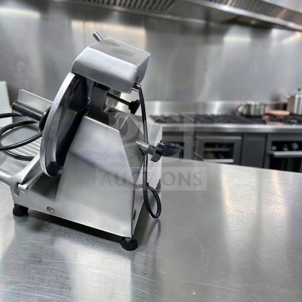 Globe C10 Chefmate meat slicer, 10" blade, stainless steel, belt driven, 1/4 HP, 115V, top-tier condition, kitchen setting.