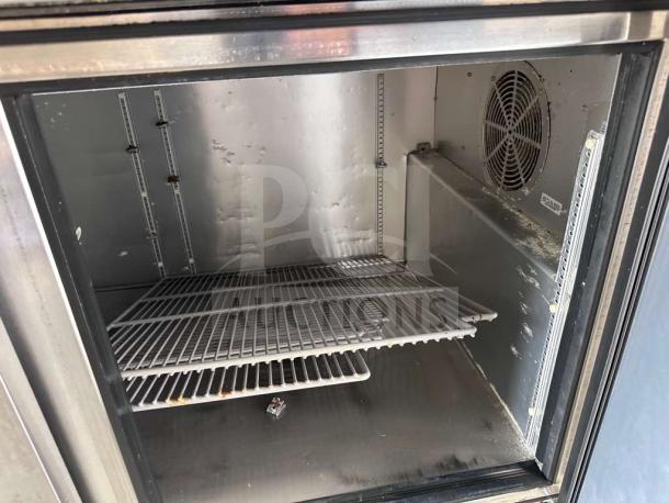 Interior view of a True TPP-AT-67-HC pizza prep table refrigerator. Features adjustable wire shelves, fan, and stainless steel interior.