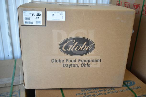 Box containing a brand new Globe G12 commercial meat and cheese slicer, featuring a 12" blade and sharpener. Model and serial labels visible.