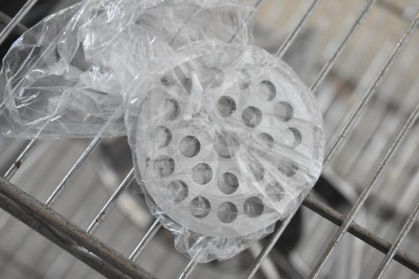 BRAND NEW Pro-Cut OKG12SS electric meat grinder parts in plastic wrap, viewed on a metal rack.