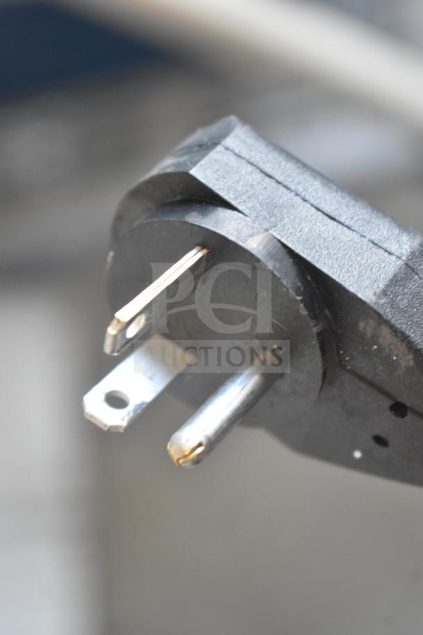 Close-up view of a three-prong plug for the 2026 Delfield CAB2-1013ET heated dish dispenser, showing the prongs' condition.