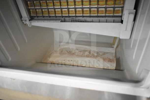 Hoshizaki KM-151BAH ice machine interior, showing crescent cube trays. Some dirt visible, self-contained unit, 115V.