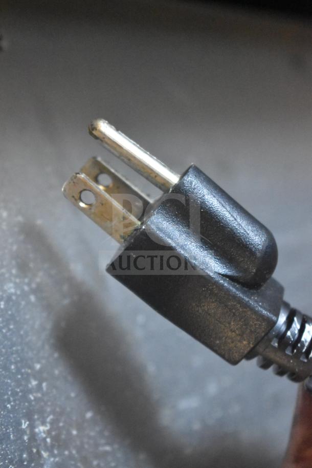 Close-up of a black 120-volt plug attached to the BevLes HPIC-3836 Heated Holding Cabinet.