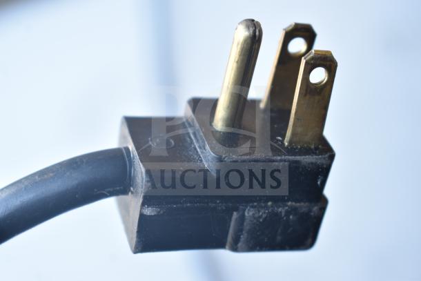 Close-up of a power plug for a Beverage Air SPED60HC-08C-2 refrigerated prep table, showing its prongs and black casing.