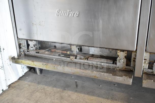 Garland SunFire X60-10RR commercial range, 10 burners, 2 ovens, back splash, on casters, shows usage wear.