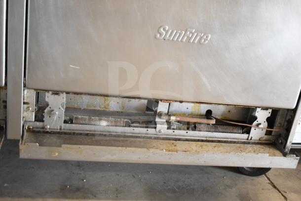 Garland SunFire X60-10RR commercial propane gas range, 10 burners, 2 ovens, with visible signs of wear, on casters.