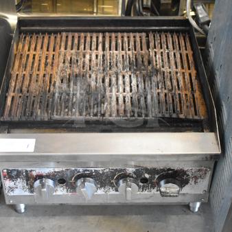 Commercial countertop gas charbroiler grill, steel construction, used condition, multiple heat control knobs, visible wear.