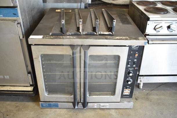 Duke stainless steel commercial full-size convection oven with view-through doors, thermostatic controls, and metal legs.