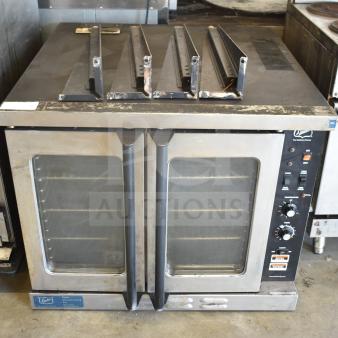 Duke stainless steel commercial full-size convection oven with view-through doors, thermostatic controls, and metal legs.