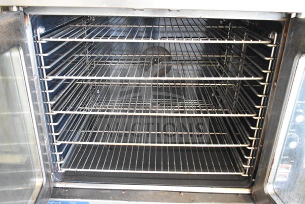 Duke stainless steel commercial full-size convection oven, view-through doors, thermostatic controls, metal legs.