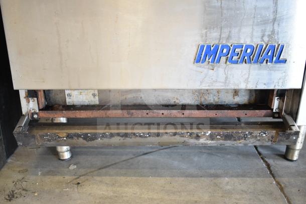 Imperial IR-6-E commercial electric 6-burner range with oven, visible wear, with Imperial logo and power specifications tag.