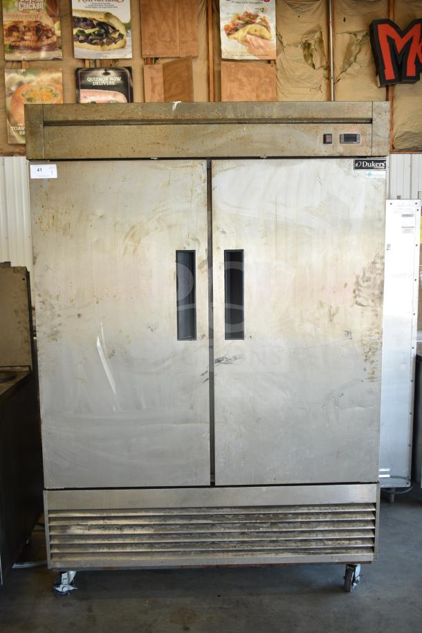 Dukers D55R Commercial 2 Door Reach In Cooler, stainless steel, 115 volts, 1 phase, visible wear, on wheels.
