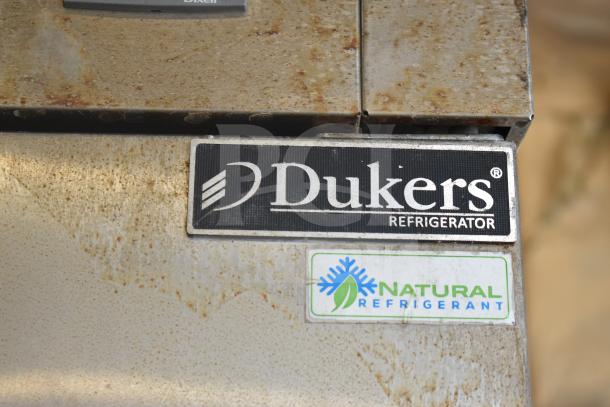 Dukers D55R Commercial 2 Door Reach In Cooler, 115 Volts, 1 Phase, visible wear and rust, featuring natural refrigerant label.