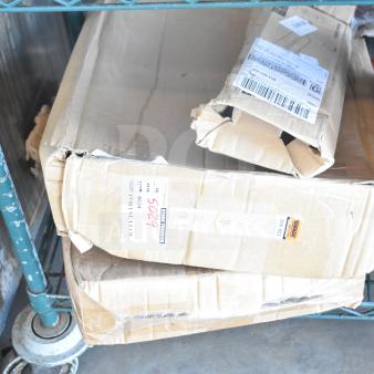 Three damaged boxes labeled "Brand New Scratch and Dent" items, including a shower caddy, on a metal shelf.