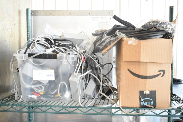 Lot of various cables and gaskets in plastic bin and Amazon box. Includes power cords and audio-video cables. Condition untested.
