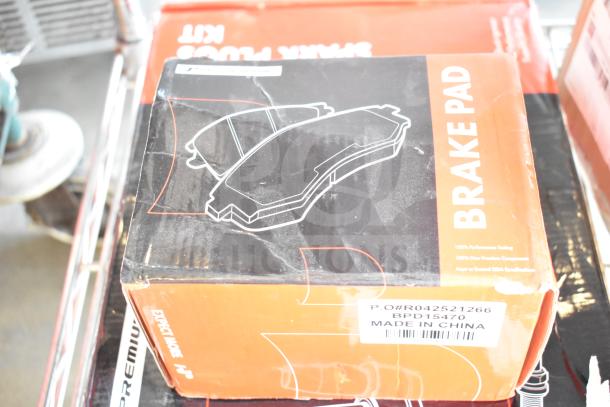 3 brand new scratch and dent items including a brake pad box labeled "Made in China." Box shows slight wear.