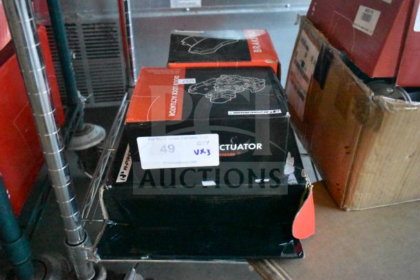 Brand new scratch and dent auto parts lot, includes door lock actuator, brake pad, and ignition coils spark plugs kit.