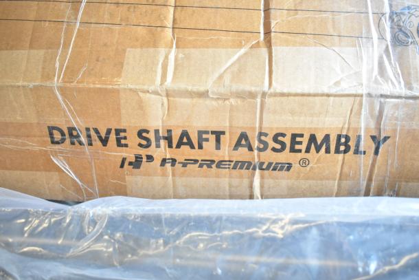 "Brand new scratch and dent Drive Shaft Assembly in original packaging, labeled 'A-Premium' with visible creases on box."