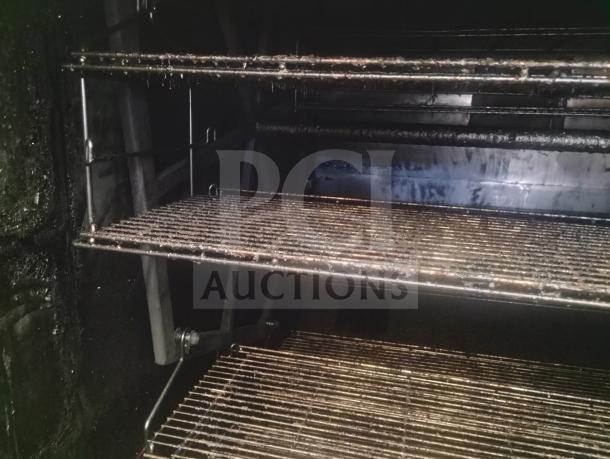 J&R Manufacturing Oyler 1300E inside view, showing metal racks and interior, used condition, 2,000 lb. capacity smoker.