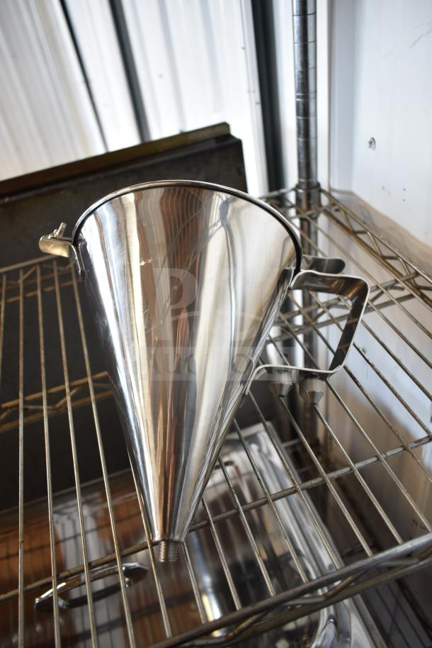 New stainless steel dough dropper hopper with handles, minor scratches visible, sits on metal rack.