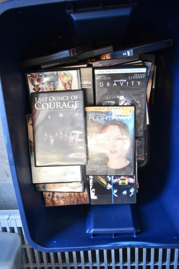 Two bins with assorted items including an LG DVD player and various DVD movies such as "Gravity" and "Last Ounce of Courage."