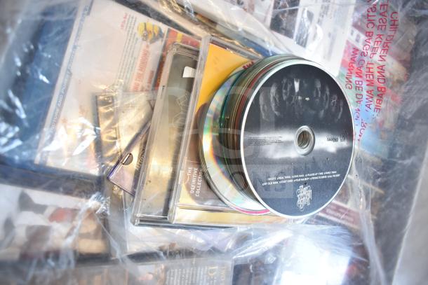 Lot of DVDs in cases and loose discs within plastic bins, various titles visible, good condition.