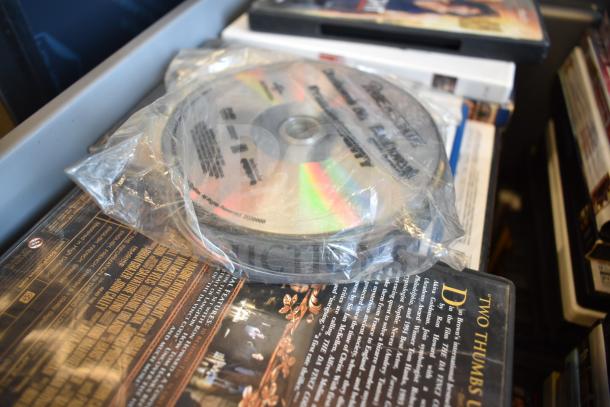 Lot of 2 bins containing various DVDs, some in cases, some loose in plastic, featuring mixed titles and genres.