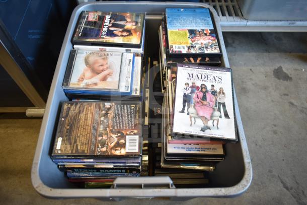 Lot of DVDs in a plastic bin, featuring various titles like "Date Night" and "Madea’s Witness Protection." Various conditions.