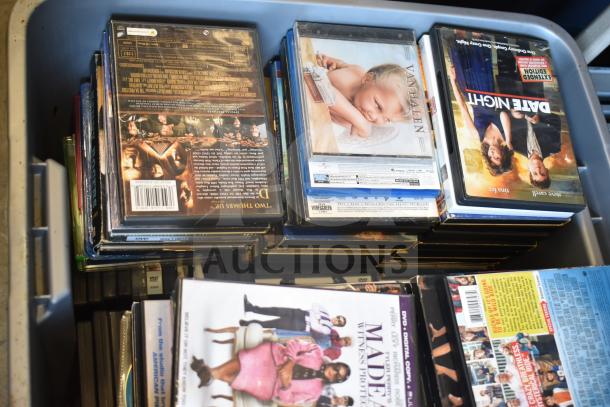 Lot of two bins filled with assorted DVDs, featuring various movie titles. Items appear in used condition.