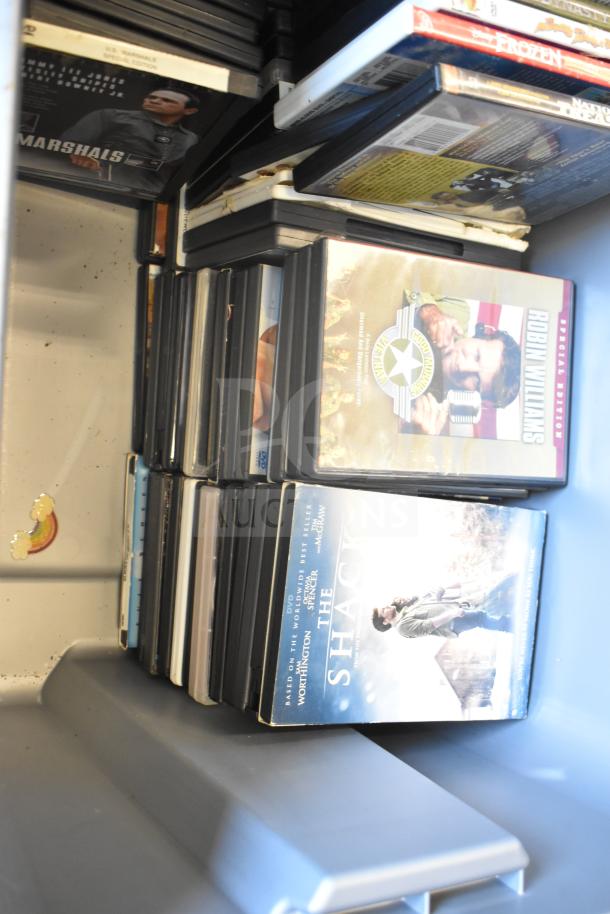Lot of DVDs in a storage bin, featuring various titles like "The Shack" and "U.S. Marshals." Items in good condition.