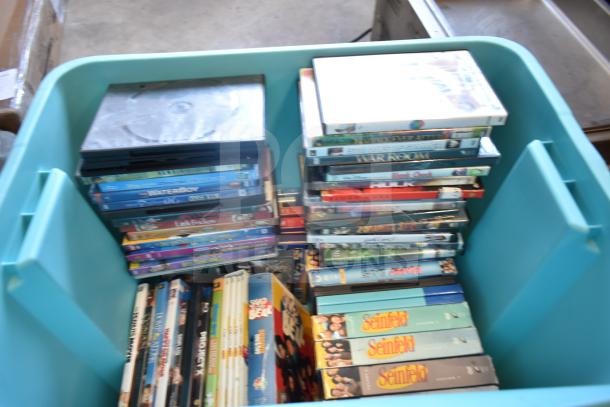 Lot of 2 bins filled with various DVDs and media, including Seinfeld and other titles. Items in used condition.