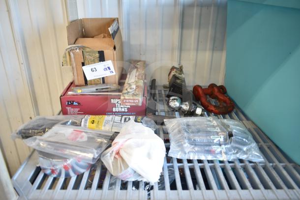 Lot of 12 items including USA Wolf Streak knife, cordless screwdriver, hitch, red shackles, and electrical tape on shelf.