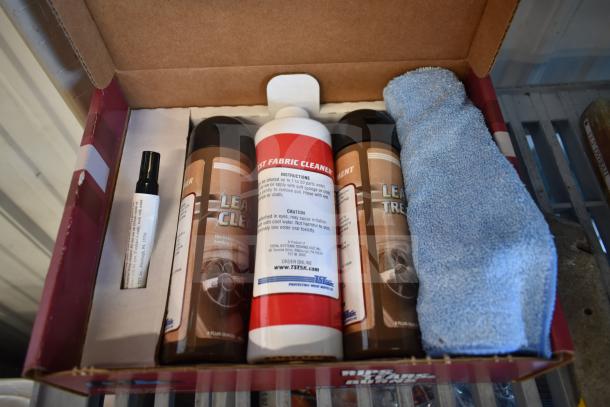 Box containing various cleaning supplies, including leather cleaner and treatment bottles, fabric cleaner, and microfiber cloth.