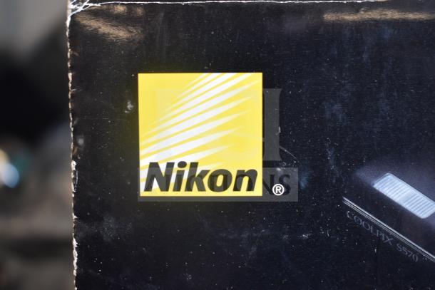 Nikon CoolPix S570 digital camera box with visible logo. Auction includes A119 dash camera.