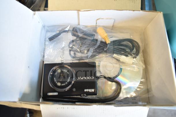 Two-item auction: Nikon CoolPix digital camera and A119 dash camera. Includes cables and user manual. Boxed condition shown.