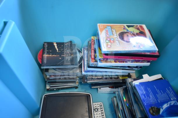 Lot of various DVDs in a blue poly bin, diverse titles, some visible covers, overall mixed condition.