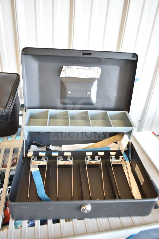 SentrySafe cash box open with multiple compartments, adjustable trays, and clips, in good condition. Includes warning label.